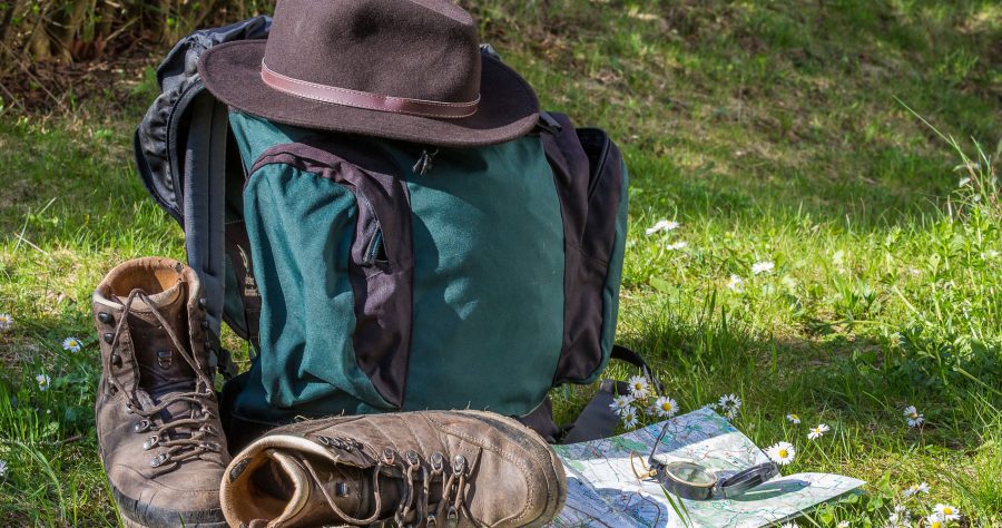 Wanderrucksack und Stiefel im Gras